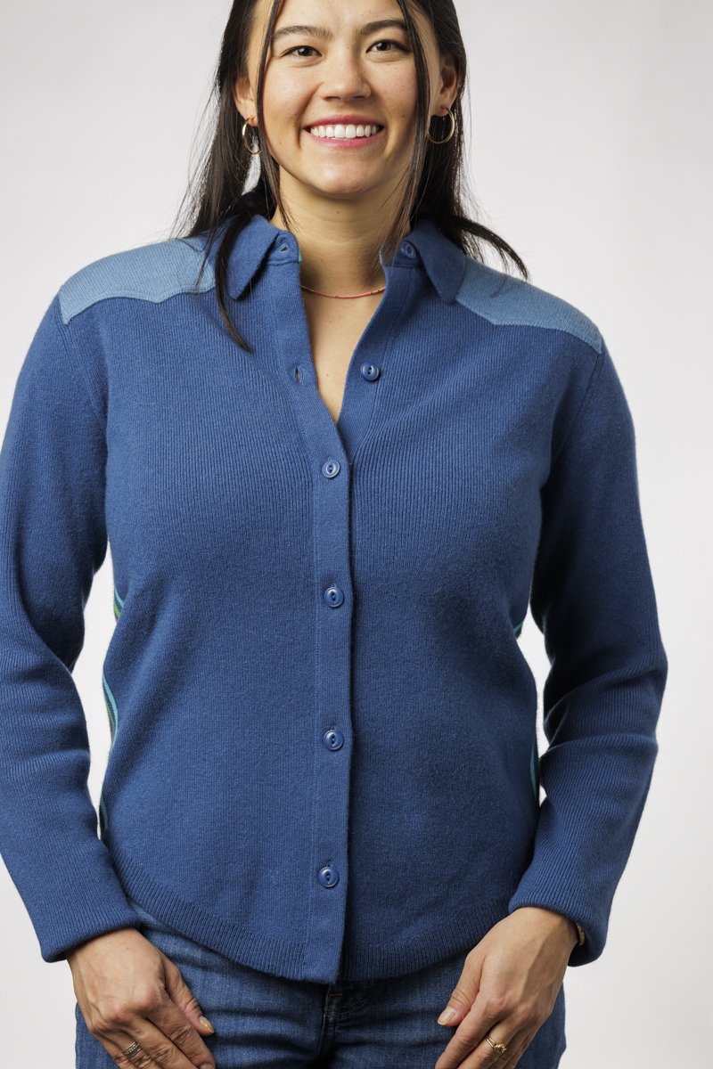 Woman wearing a blue button-up shirt with a white background
