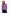 A woman wearing a purple crewneck sweater with colorful striped details on the sleeves, paired with dark blue jeans, against a plain white background. - Alpenglow