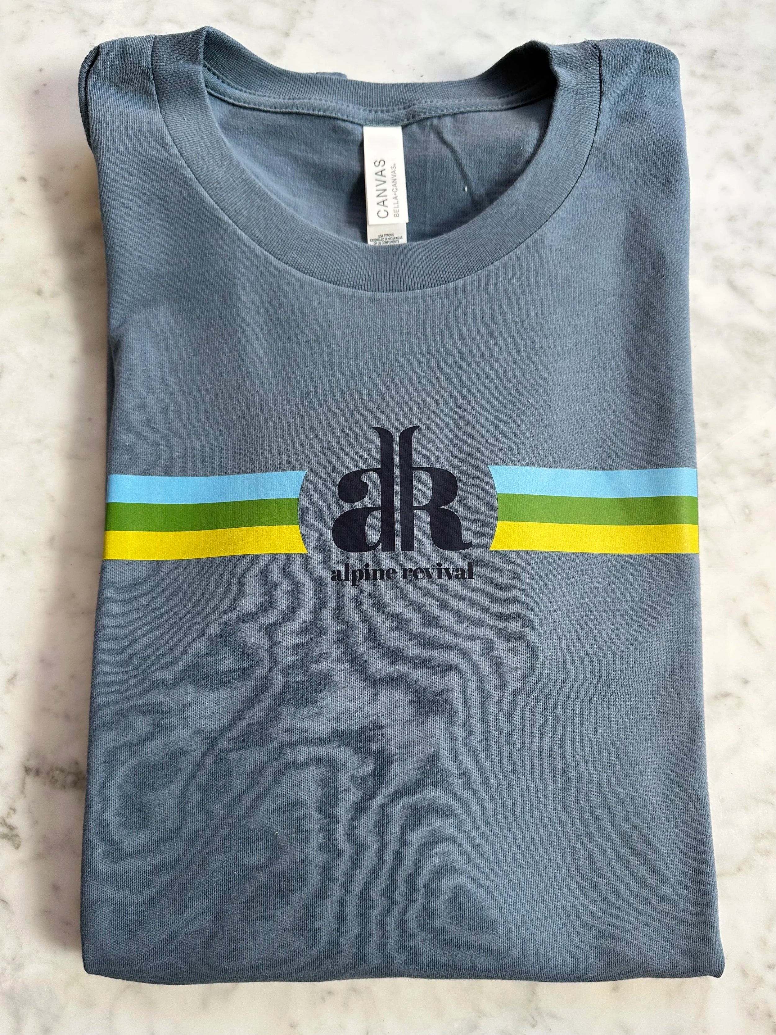 Folded blue t-shirt with a logo and text on a textured surface