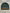 Green beanie with striped pattern and brand logo on a gray surface