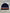 Navy blue beanie with colorful stripes on a gray surface