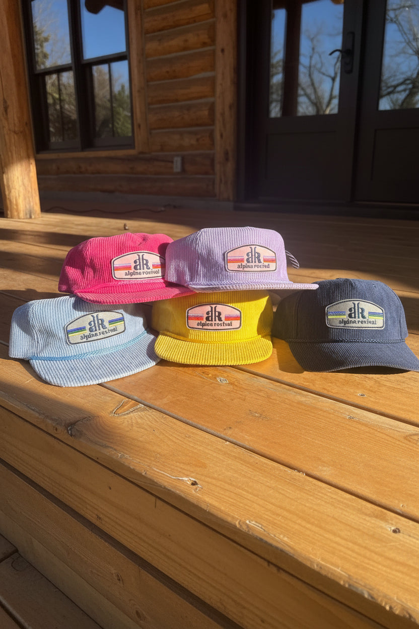 Four colorful caps with a brand logo on a wooden surface