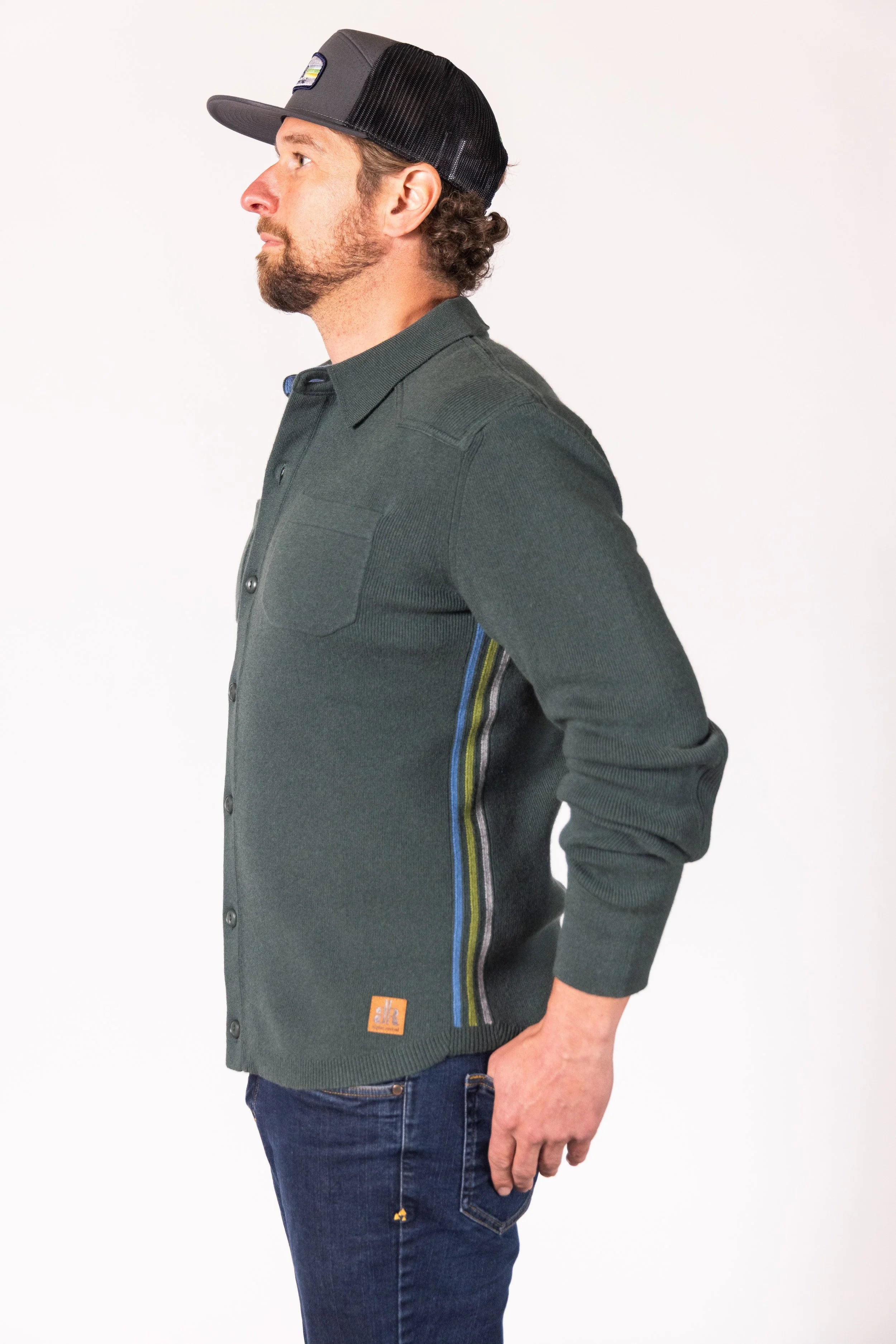 Man wearing a green shirt with a patch on a white background