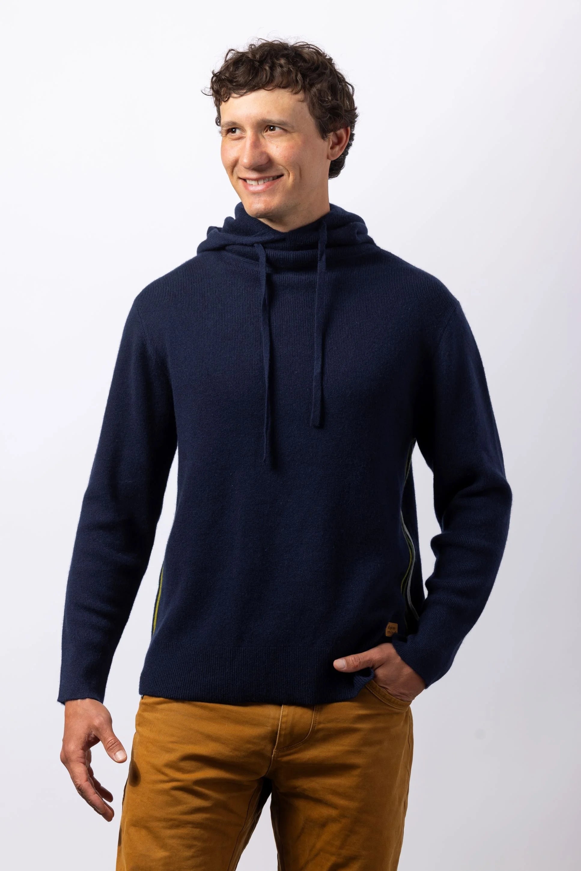 Man wearing a navy blue sweater with a hood against a white background
