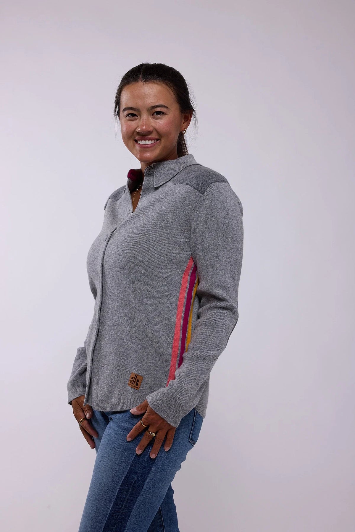 Woman wearing a gray sweater with colorful accents on a white background - Grey