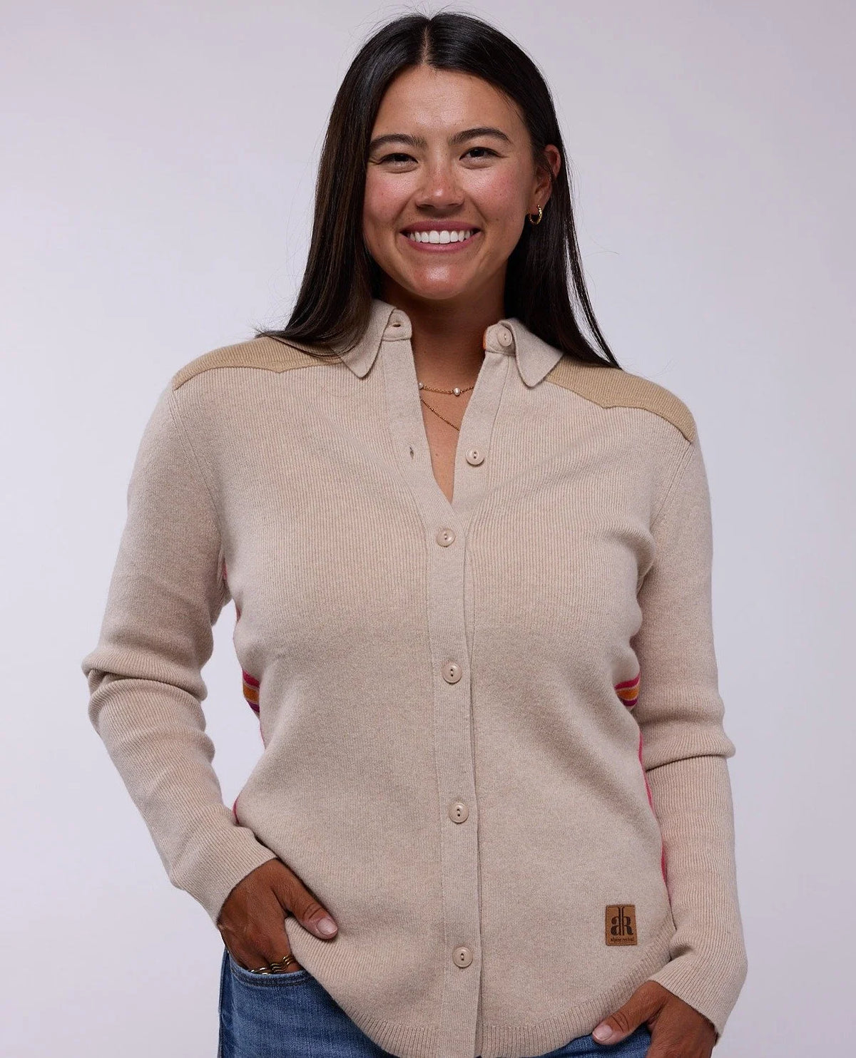 Woman wearing a beige button-up shirt with a visible brand logo on a white background - New Flax