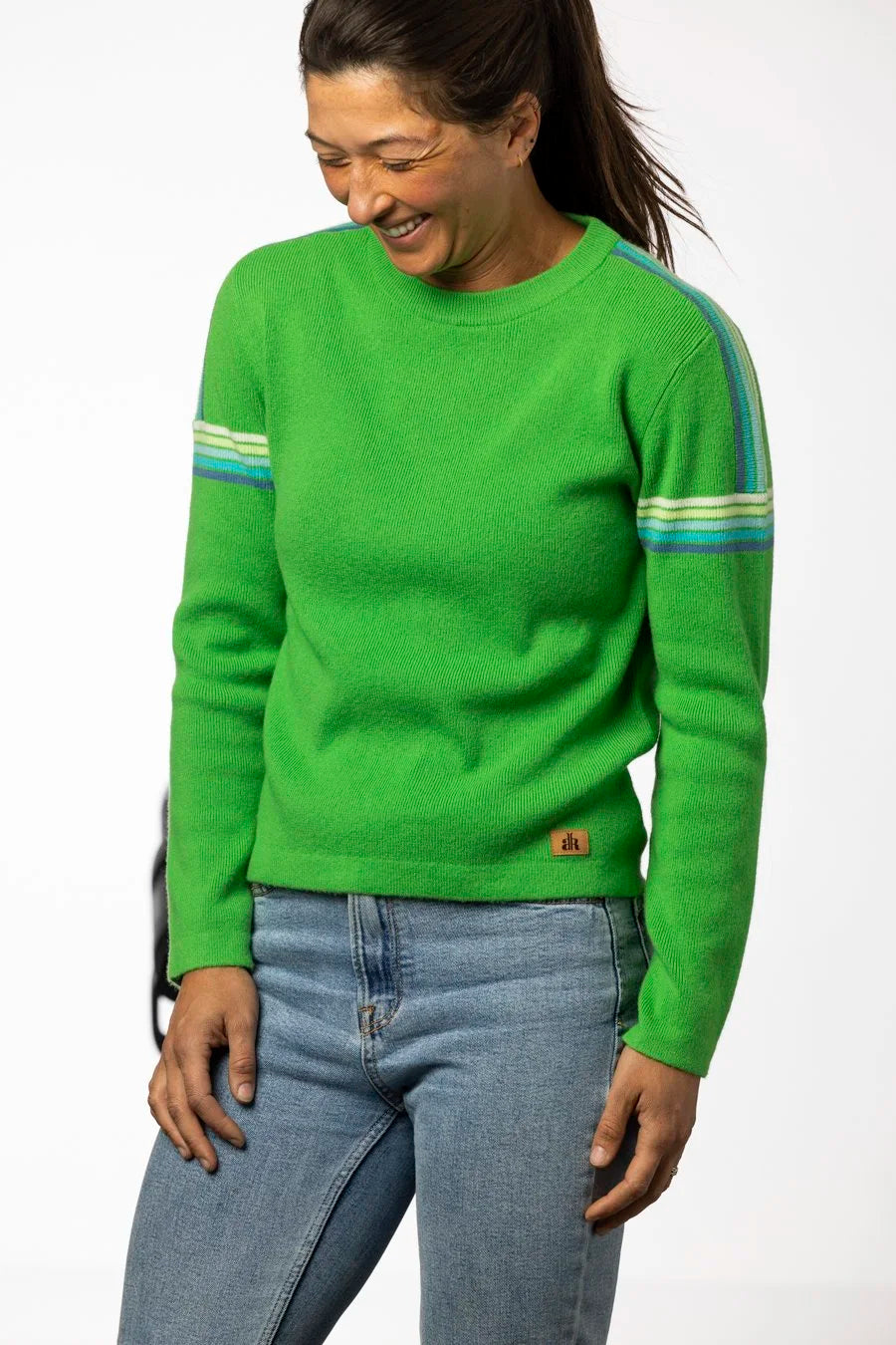 Woman wearing a green sweater with striped sleeves on a white background - Bright Green