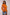 Woman wearing an orange sweater with colorful stripes on a plain background